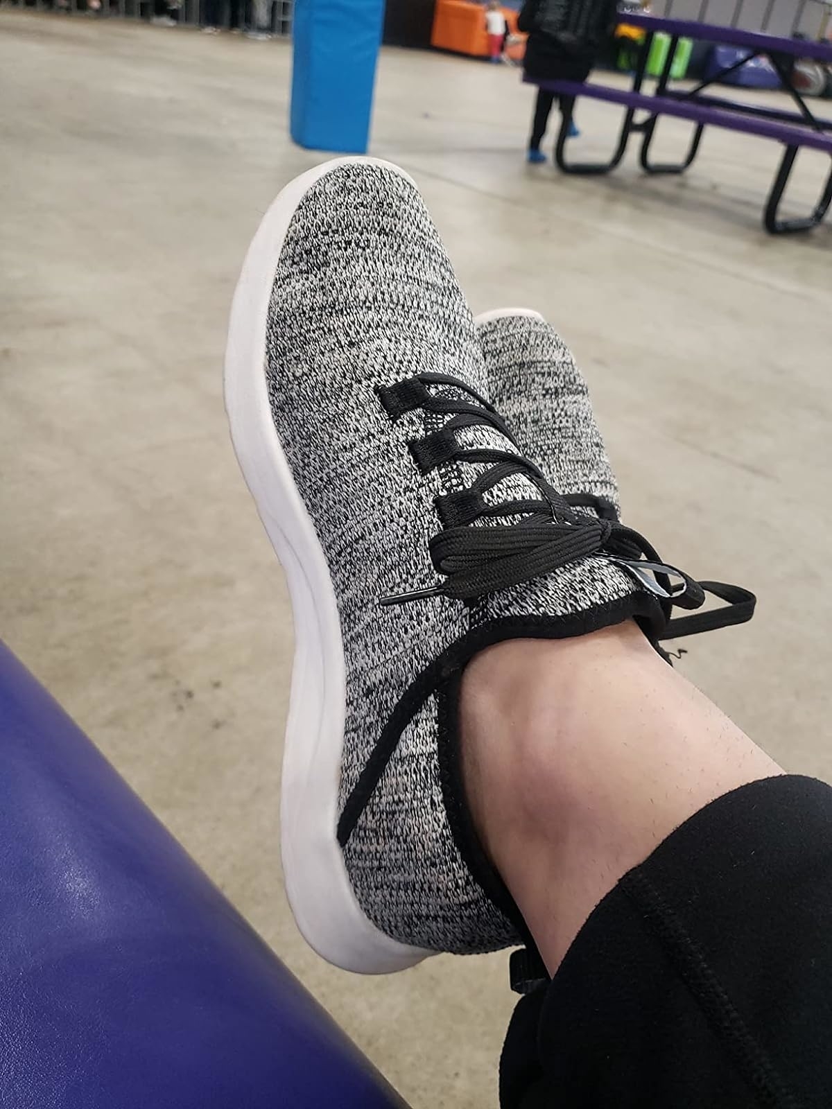 Reviewer&#x27;s photo of their feet wearing the sneakers in the color Black Gray