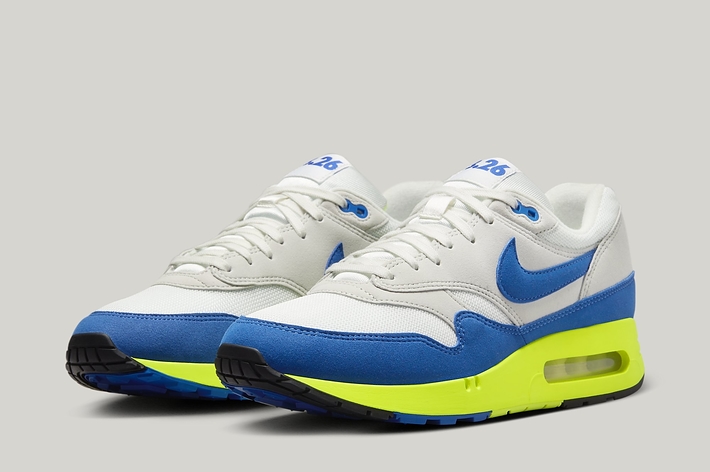 A pair of Nike Air Max 1 sneakers with blue swoosh and neon sole