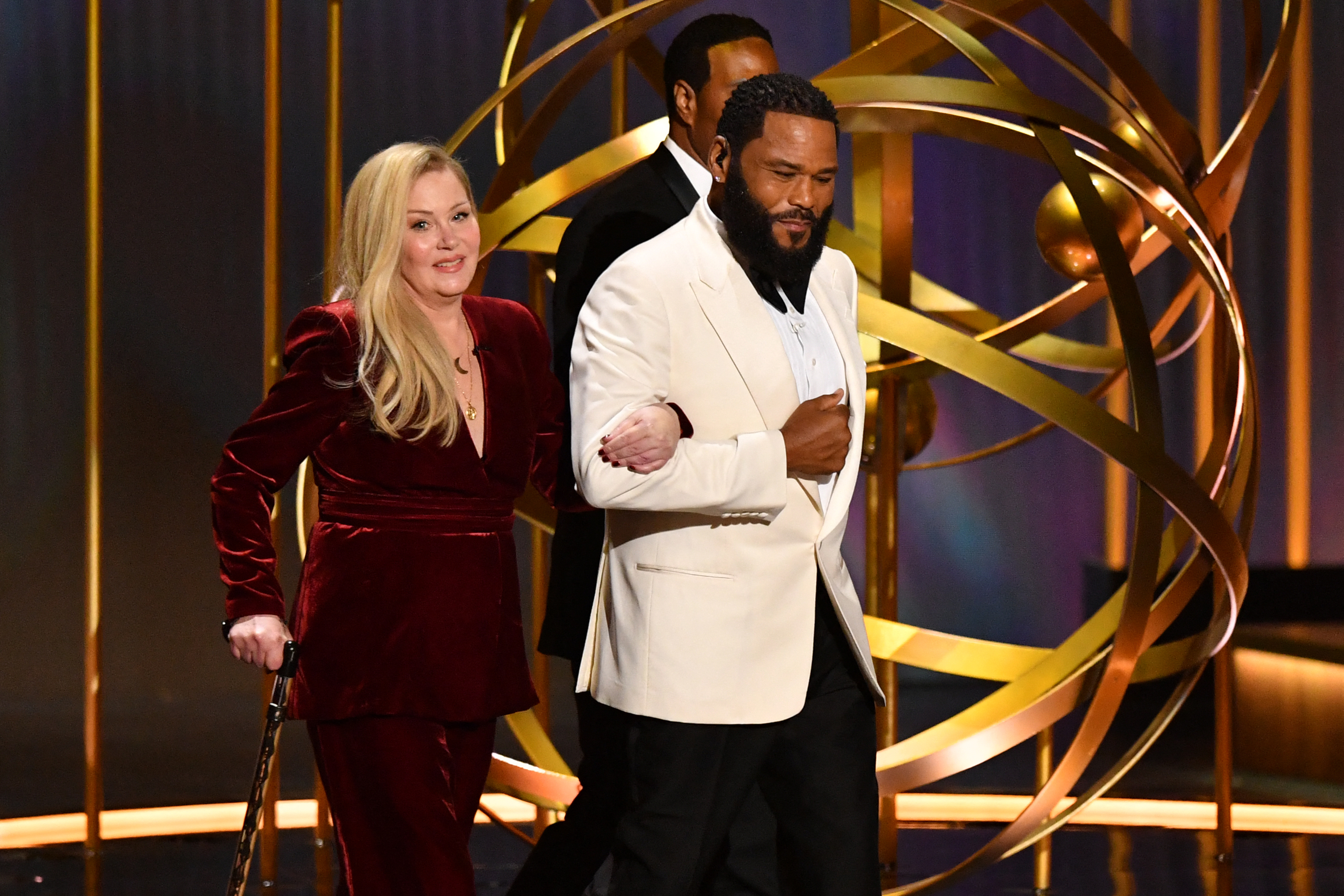 Christina walking on stage at the Emmy Awards with Anthony Anderson