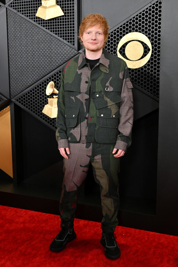 Ed Sheeran posing in a camo-patterned suit at an awards event