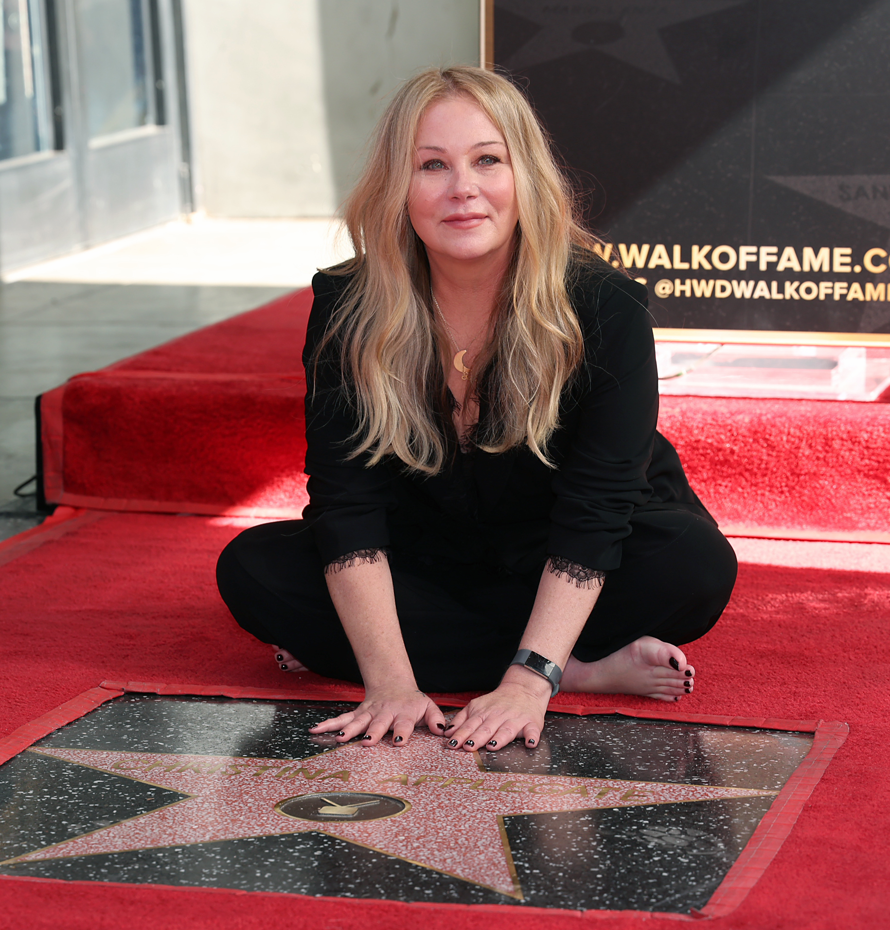 Christina Applegate sitting next to her star on the Hollywood Walk of Fame