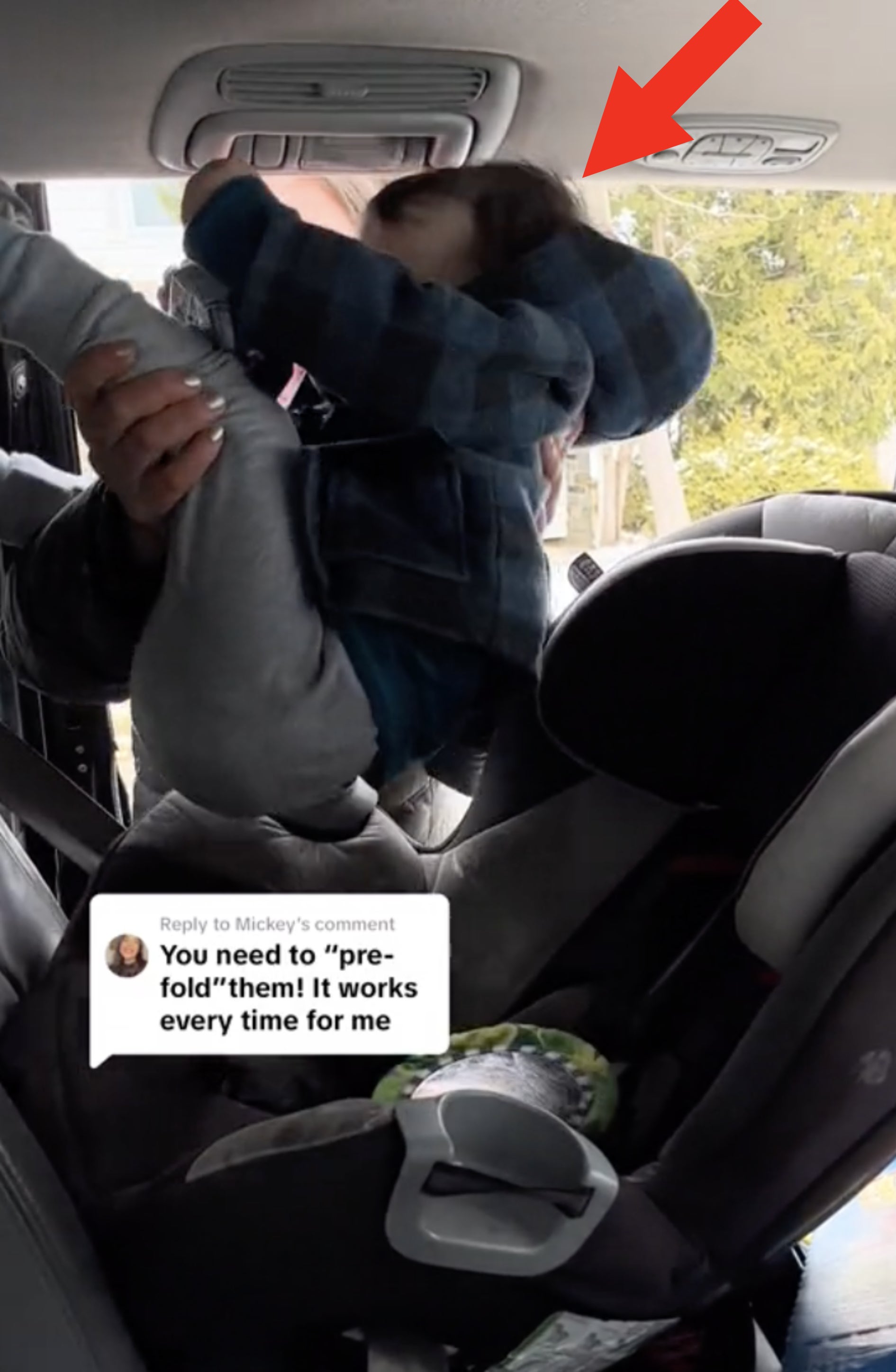 Person struggles to fit stroller in car trunk without bumping the child&#x27;s head