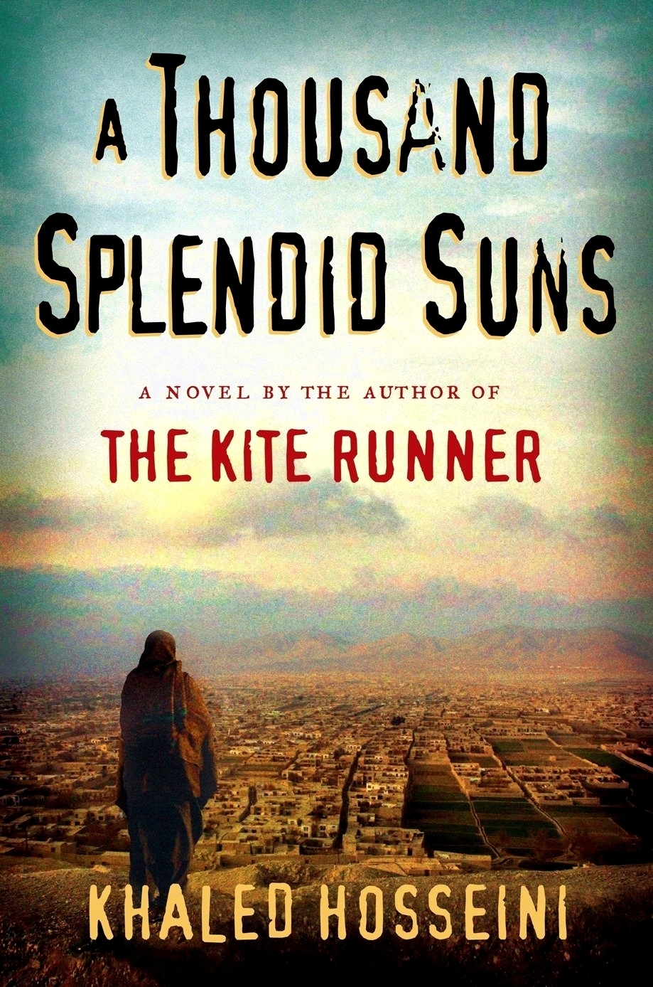 Book cover of &quot;A Thousand Splendid Suns&quot; by Khaled Hosseini, featuring a silhouette of a person walking towards a cityscape