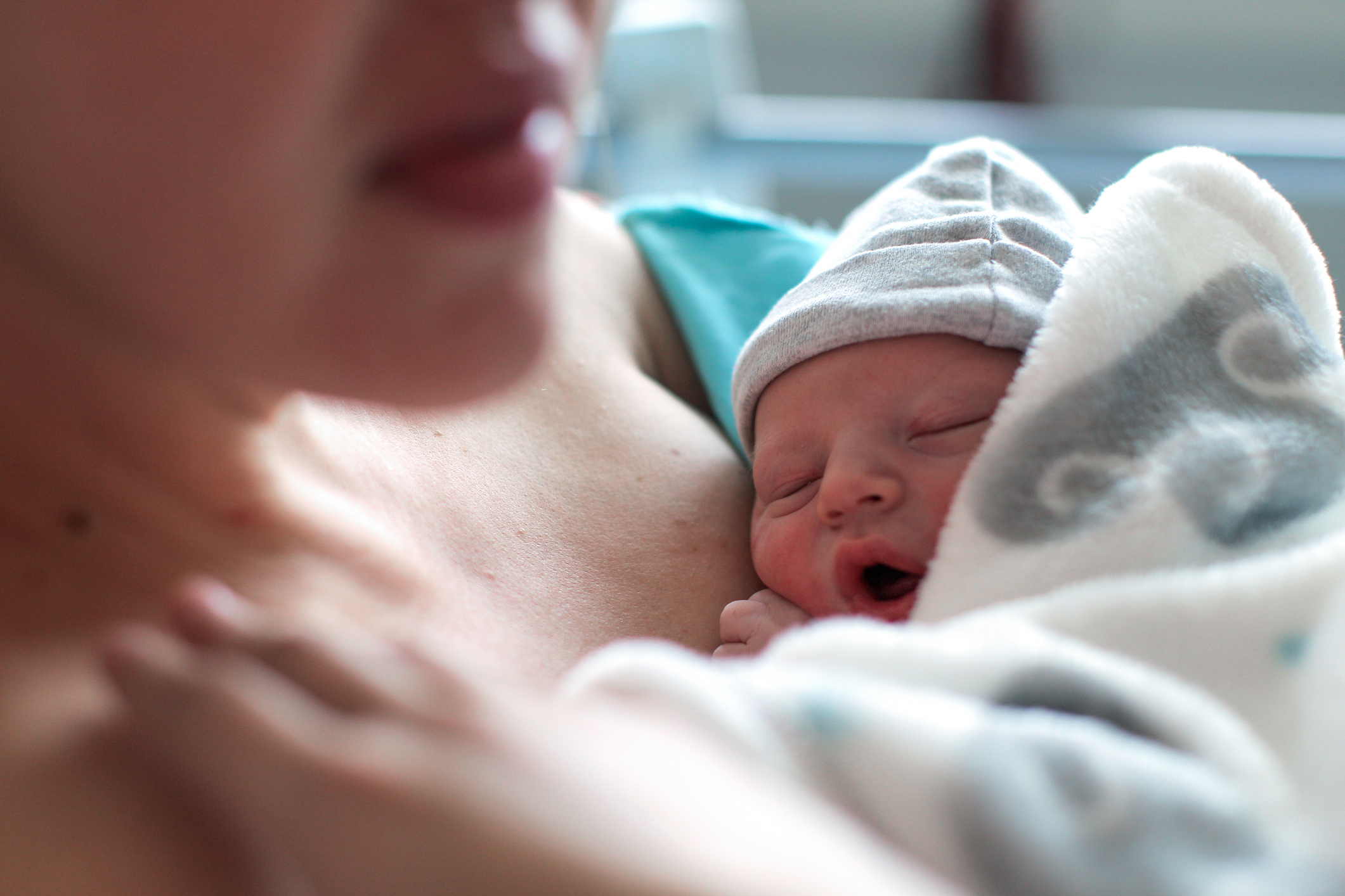 Newborn resting on a parent&#x27;s chest, both appearing content and peaceful