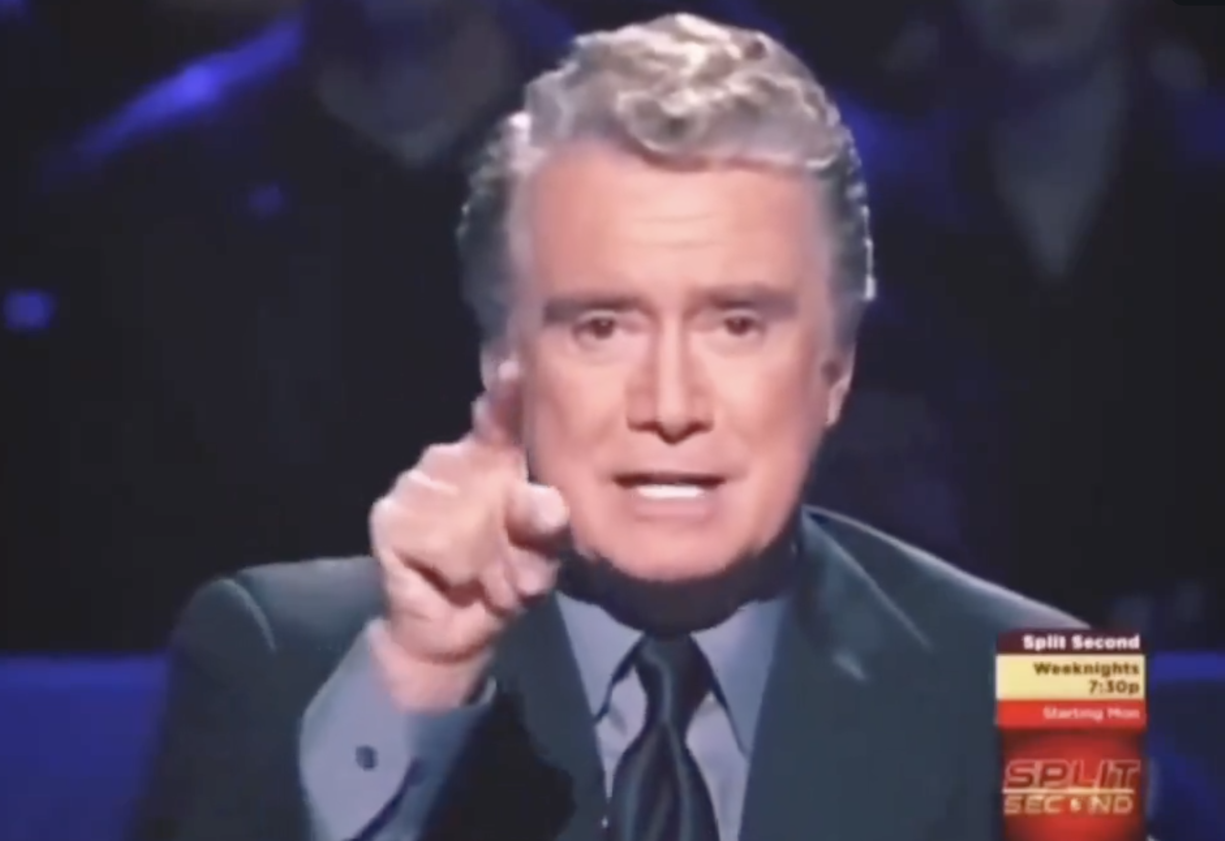 Regis gesturing toward the camera