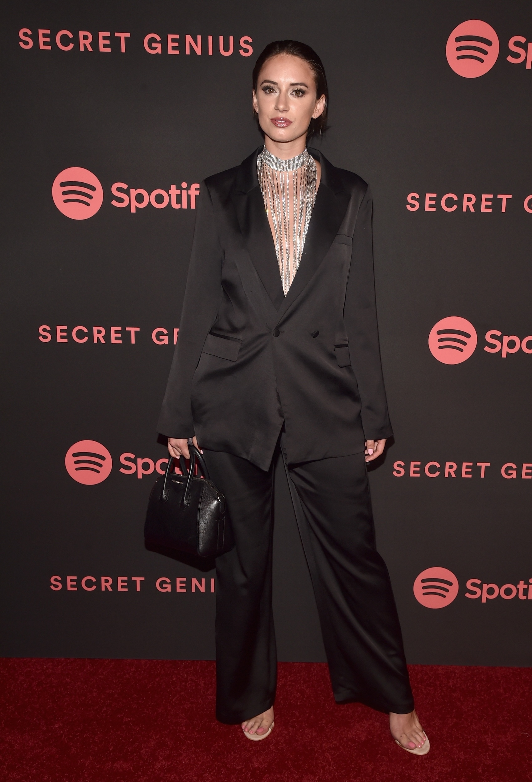 Olivia Culpo in a black suit with a beaded neckpiece at Spotify event