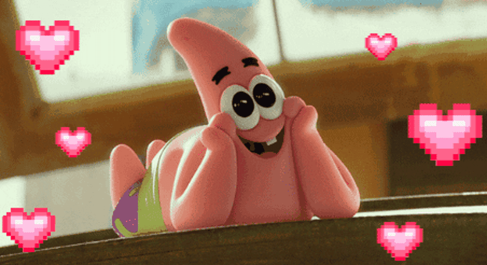 Personaje animado Patricio Estrella acostado con una expresión encantada, rodeado de corazones pixelados
