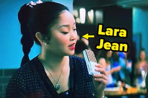Lara Jean, a character from a film, is eating an ice cream sandwich with a text arrow pointing to her