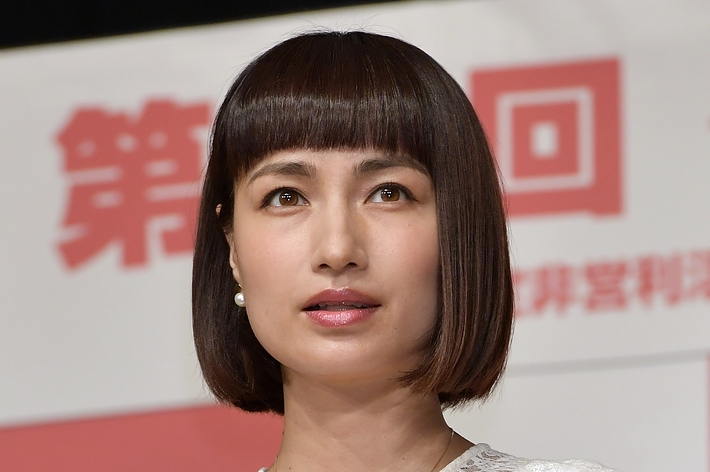 女性は白いレースのトップスを着て、イベントに参加しています。