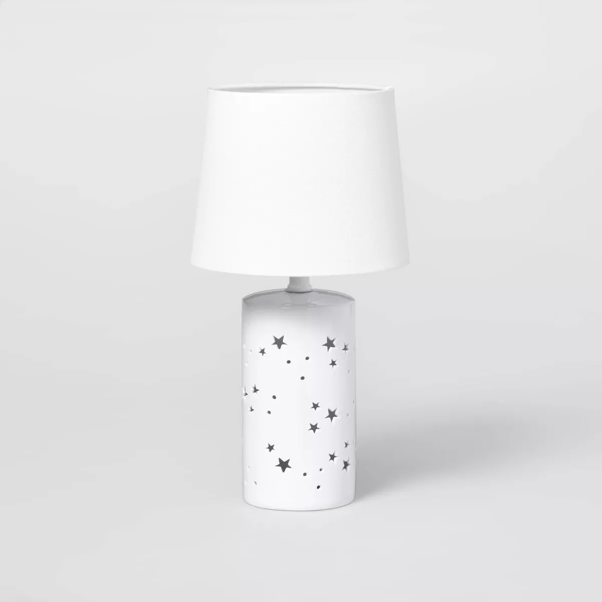 Table lamp with a star-patterned base and plain lampshade