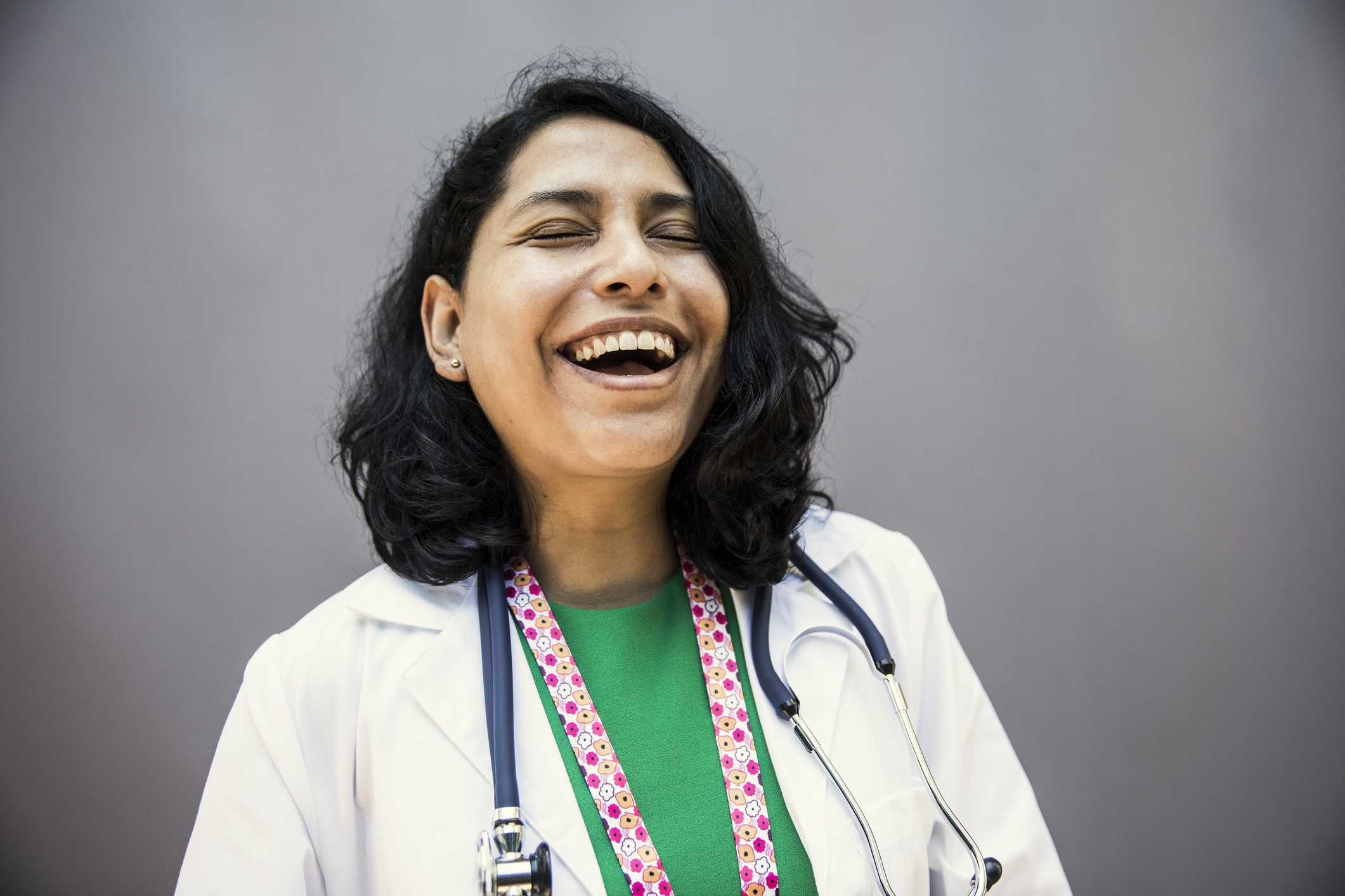 A joyous doctor with a stethoscope laughing