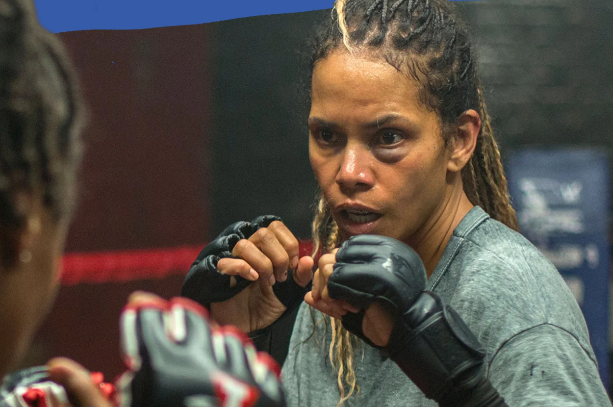 Woman with braided hair in workout gear practicing boxing in front of a mirror