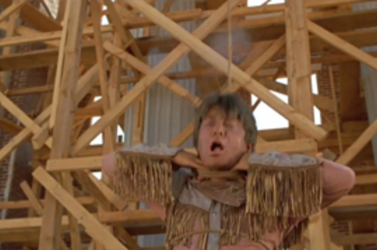 Man trapped in a wooden pillory with a surprised expression, wooden structure background