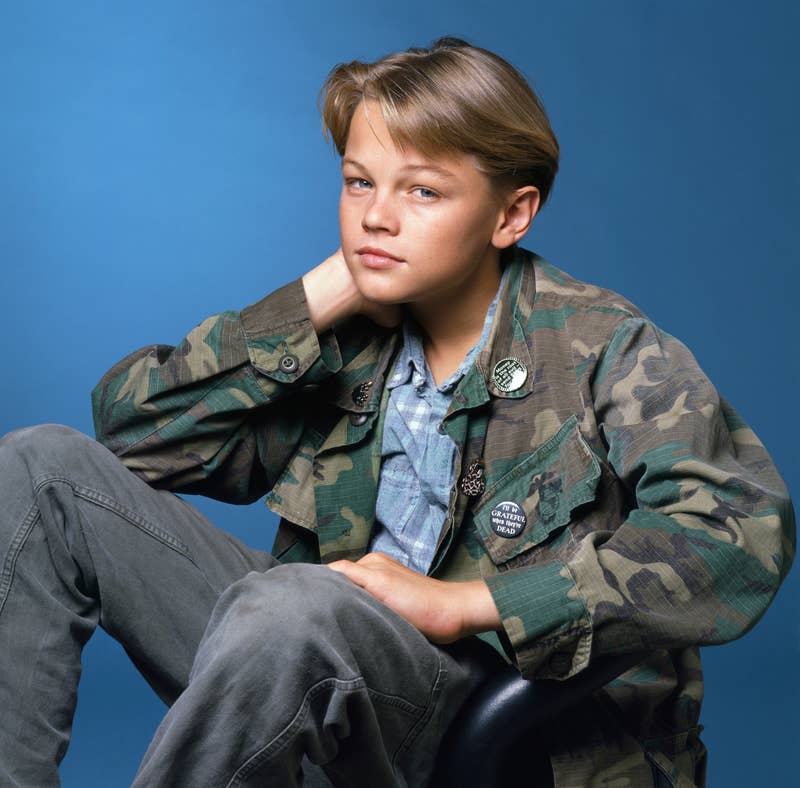 Young Leonardo DiCaprio posing casually, wearing a camouflage jacket and denim