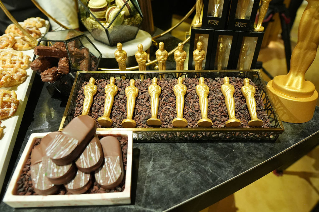 Oscar statue-shaped chocolates on display among various desserts at an event