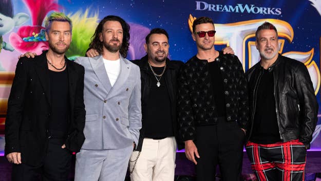 Five members of the Backstreet Boys pose together at a DreamWorks event. They are dressed in various trendy outfits