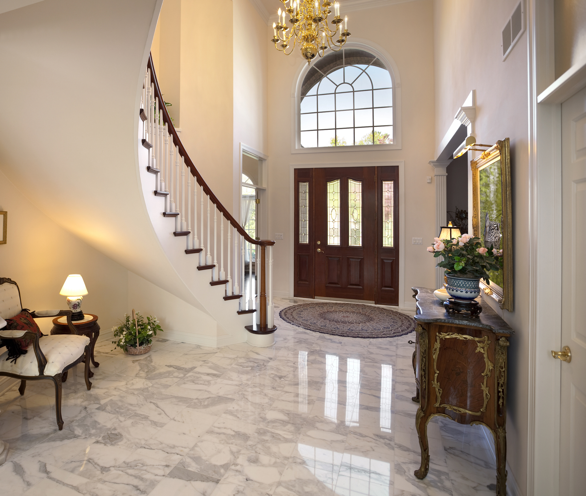 Elegant home entryway with staircase, chandelier, and double front doors