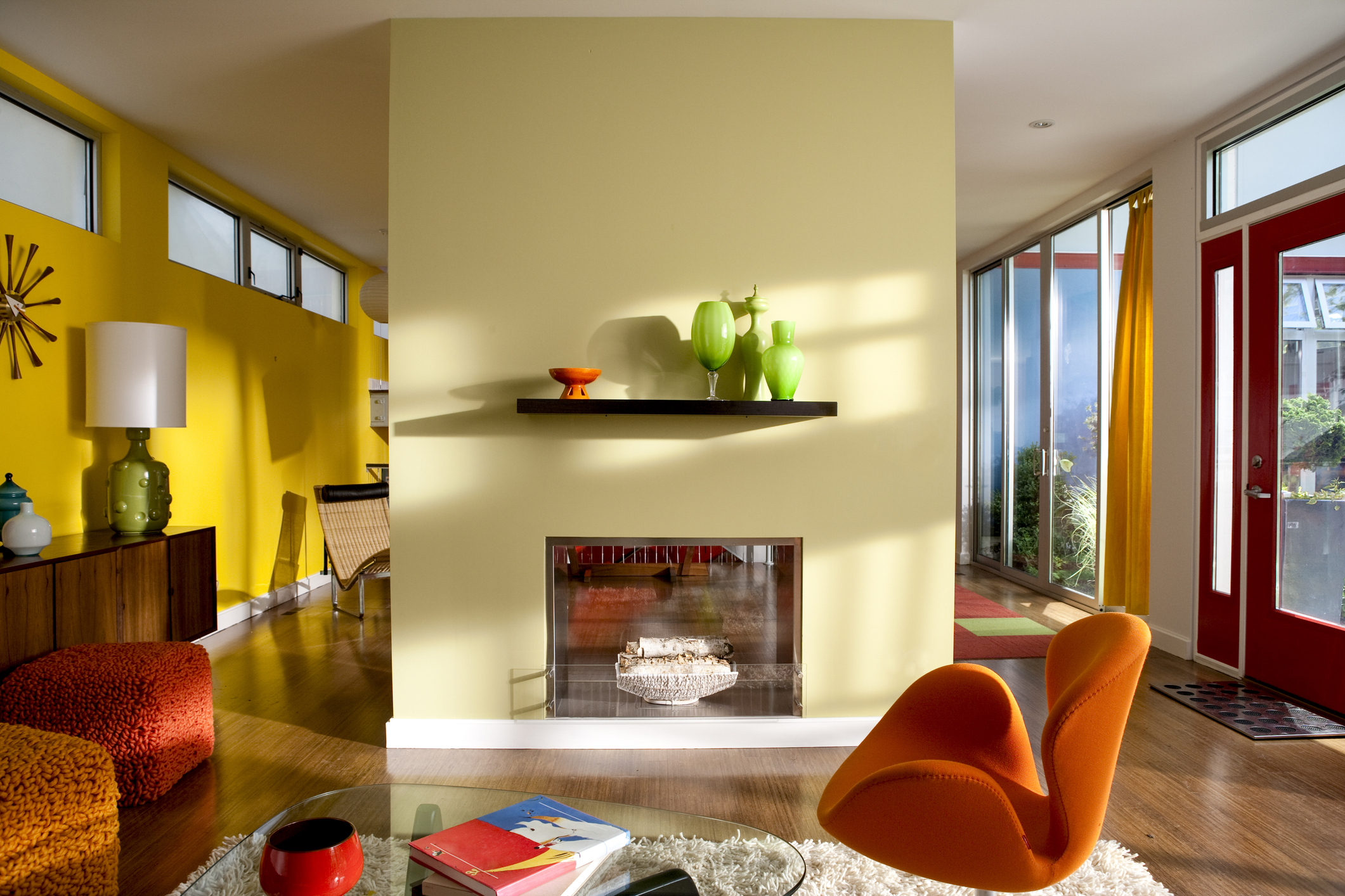 Interior room with modern furniture a fireplace and a vibrant orange chair