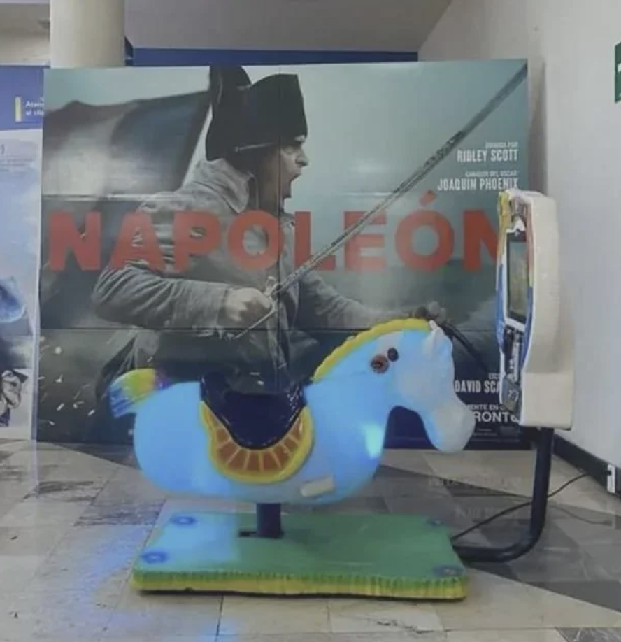 Promotional movie display for &quot;Napoleon&quot; with Joaquin Phoenix and a coin-operated ride-on horse in the foreground