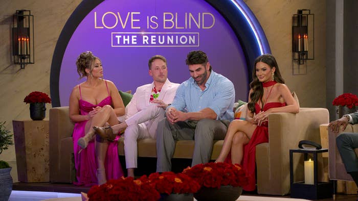 Cast members on 'Love is Blind' reunion sitting on stage, with one woman in a light dress and another in a darker dress