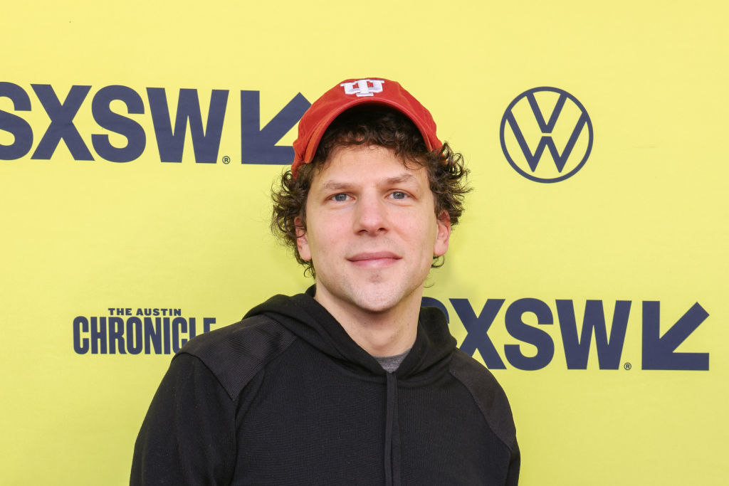 Jesse in a red cap and black hoodie standing in front of a SXSW sign