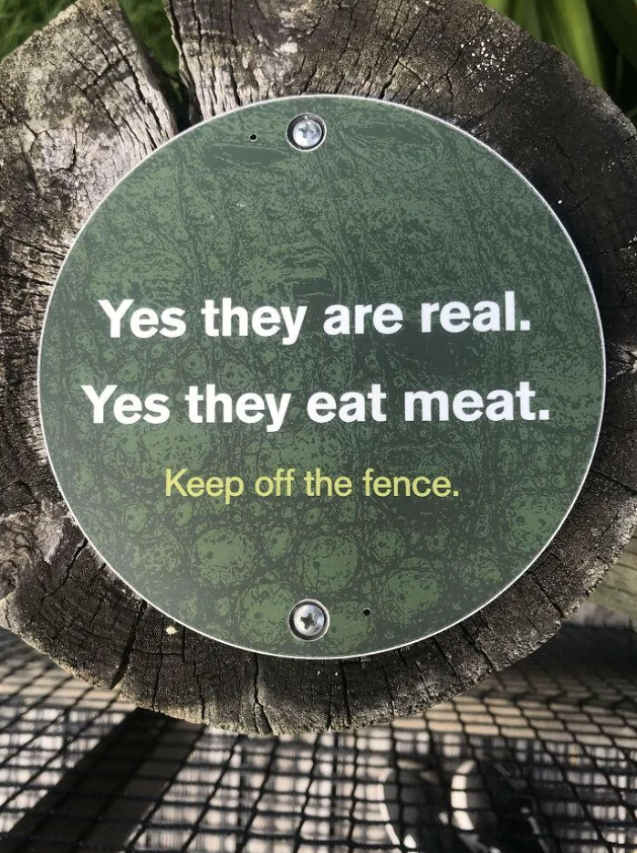 Sign on a fence warning: &quot;Yes they are real. Yes they eat meat. Keep off the fence.&quot;
