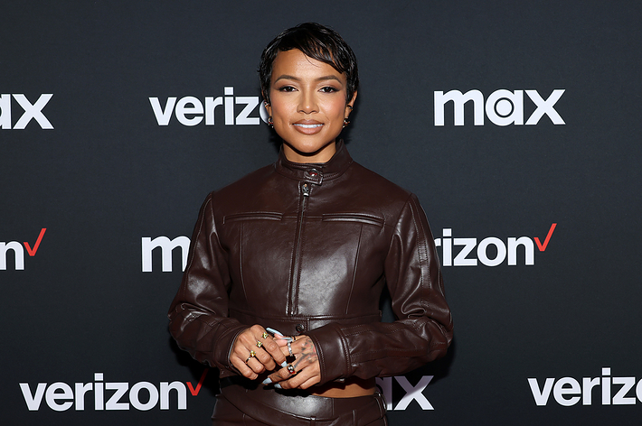 Woman in a fitted brown leather jacket posing for a photo