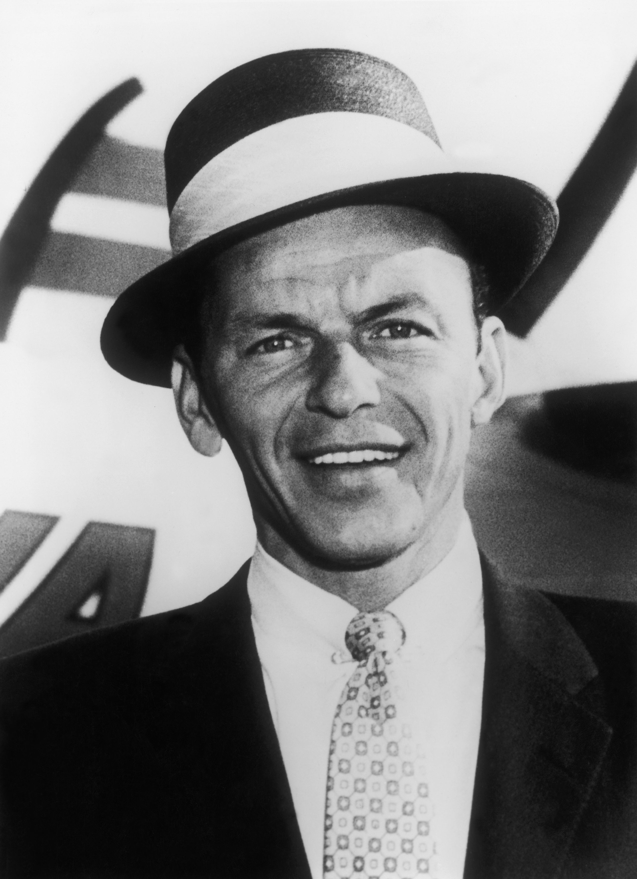 Frank Sinatra wearing a classic suit and fedora hat
