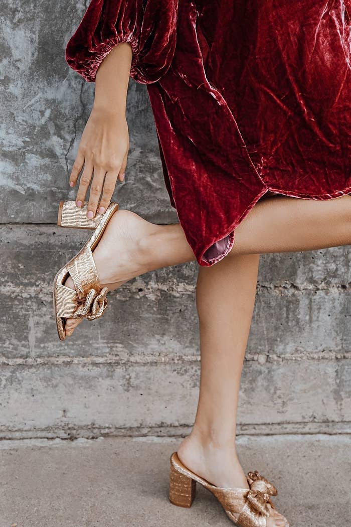 Model wearing rose gold-tone knotted sandals