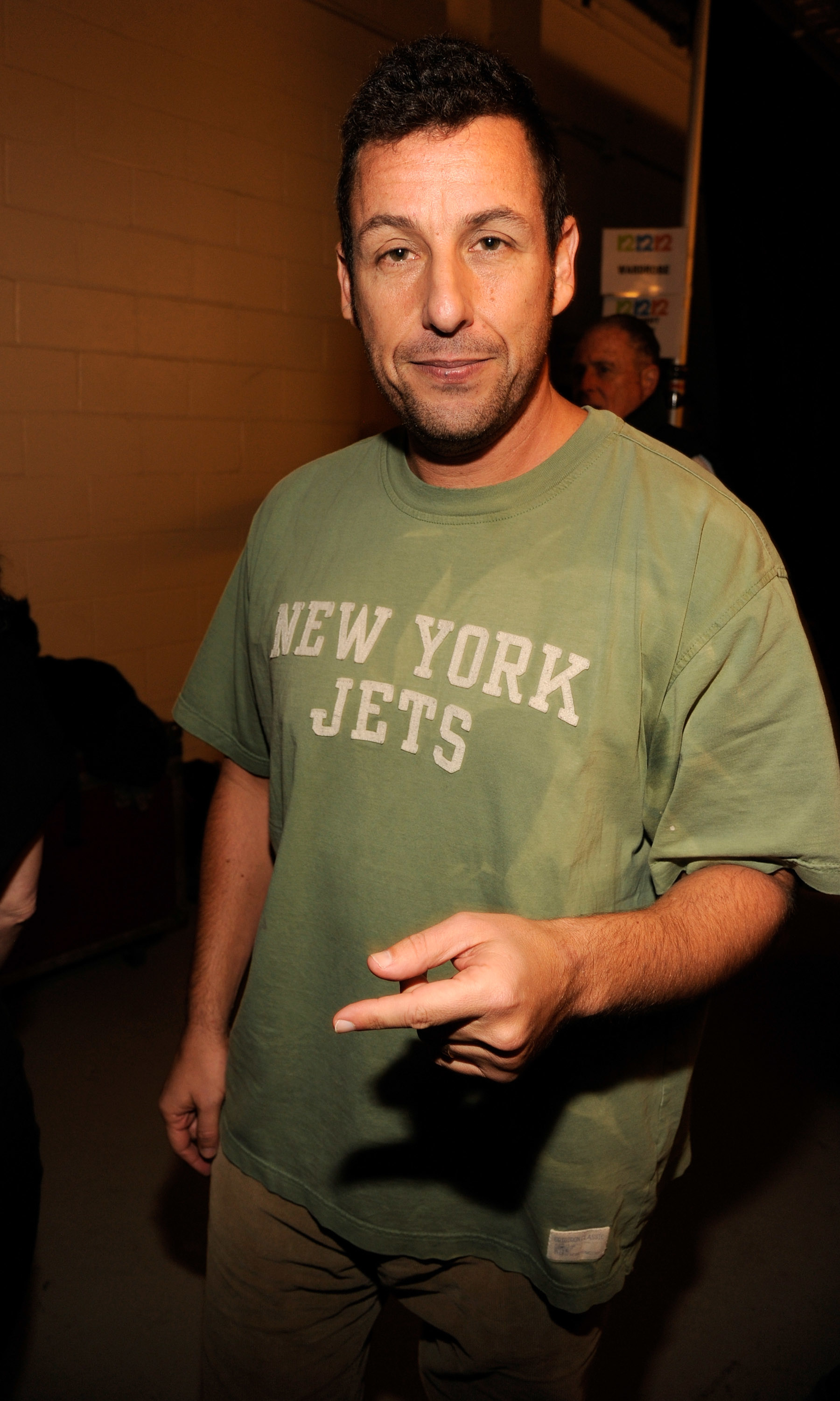 Adam wearing a &quot;New York Jets&quot; T-shirt, gesturing with his hand