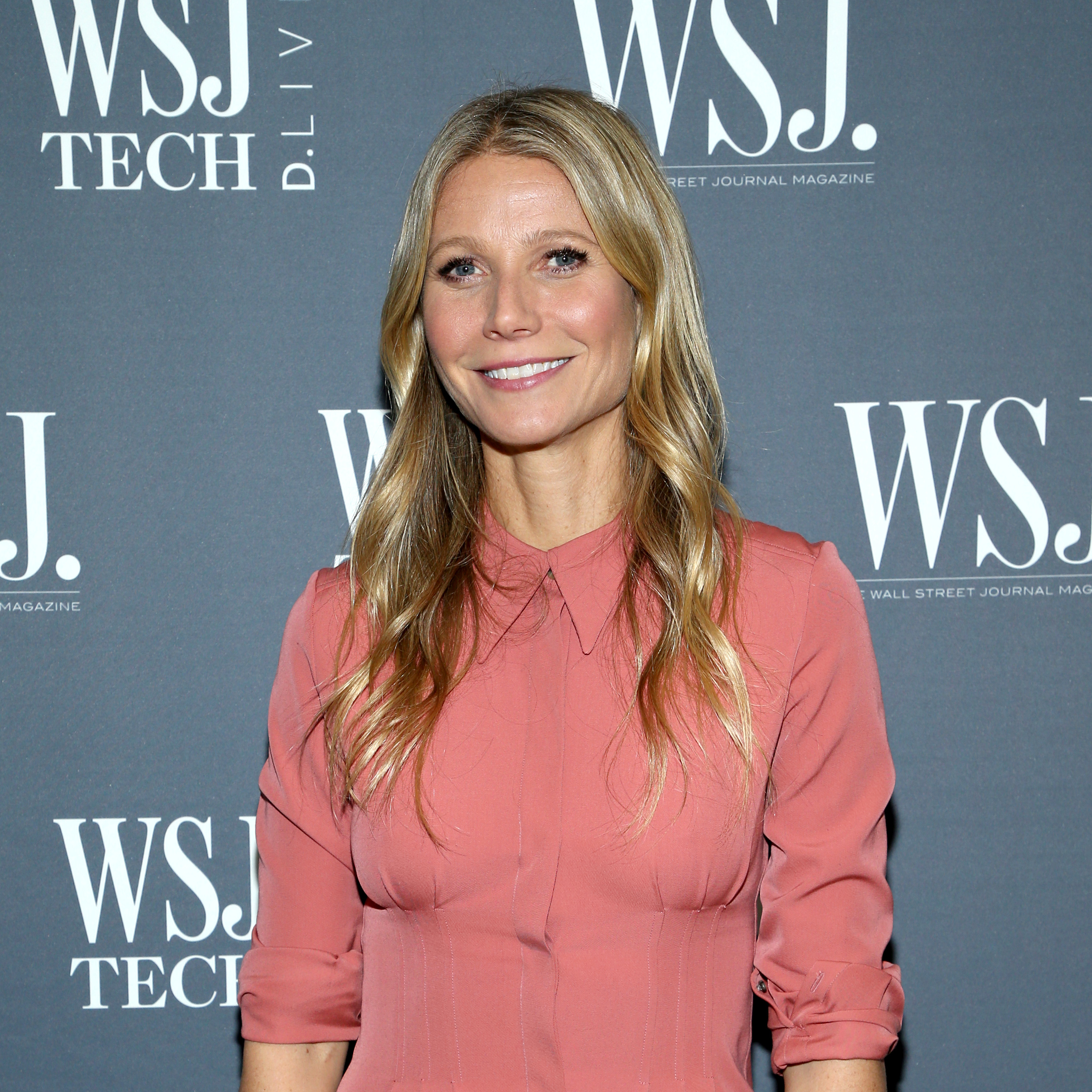 Gwyneth Paltrow in a pink blouse poses at the WSJ Tech event
