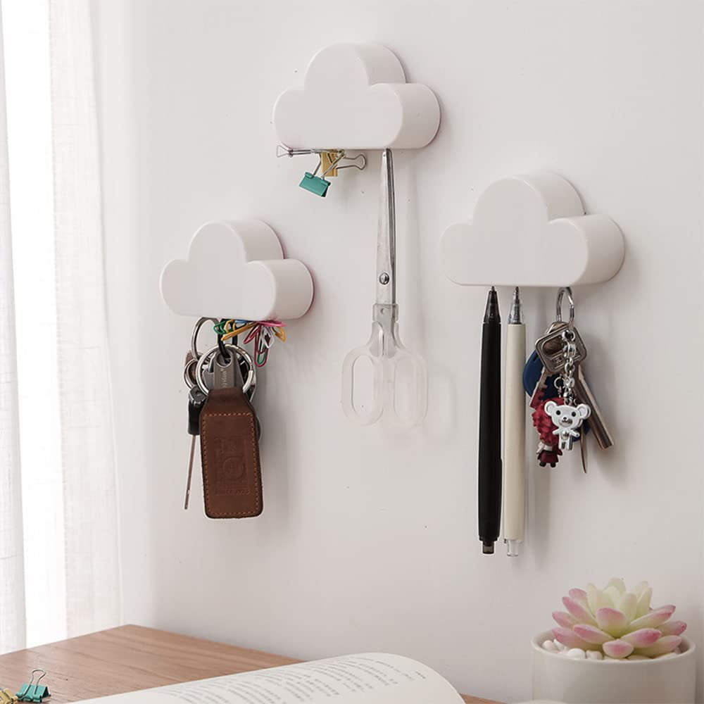 Wall-mounted key holder with cloud design and three hooks holding keys and kitchen utensils