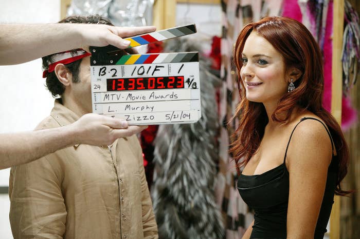 Lindsay smiling on set with someone holding a clapperboard in the foreground