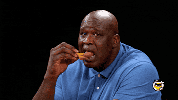 Man in blue polo shirt eating a chicken wing