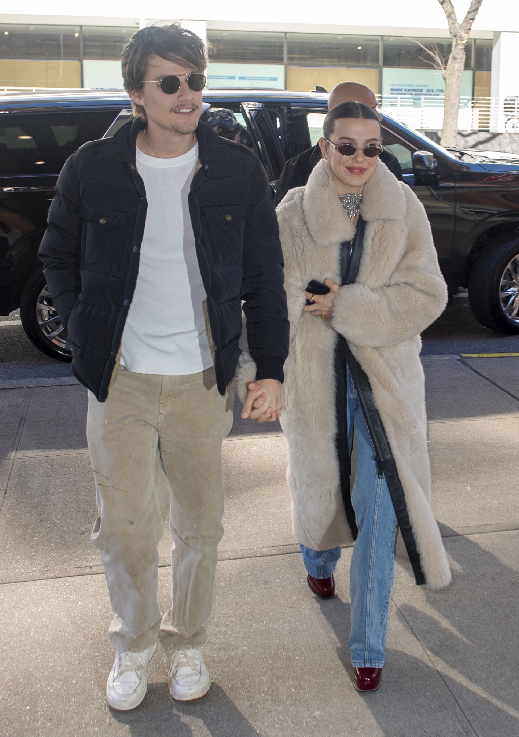 Jake Bongiovi and Millie Bobby Brown walking from a car