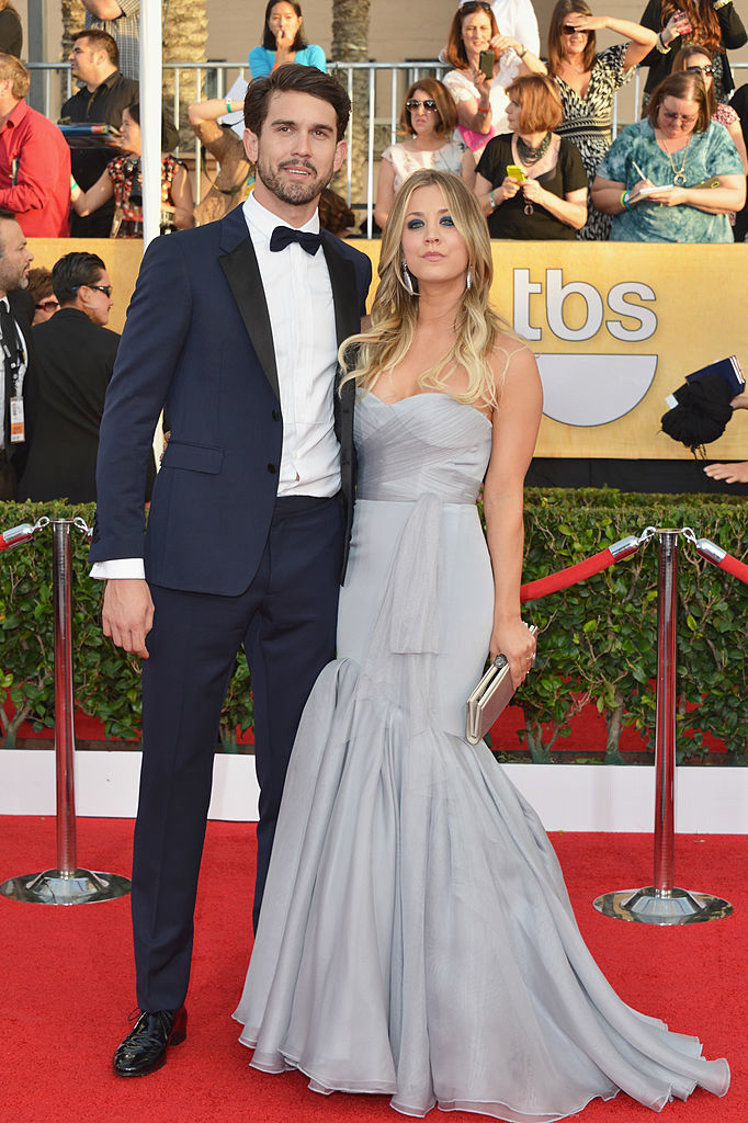Ryan in a navy suit and bow tie and Kaley in a strapless gray gown with clutch on the red carpet