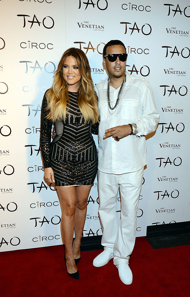 Khloé in a short fitted, long-sleeved dress and French in a white suit with sunglasses on the red carpet