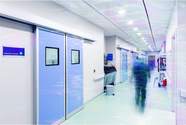 Hospital corridor with blurred motion of person walking and doors on either side