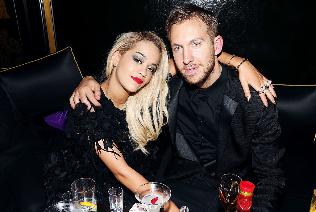 The two sitting together, Rita in a tasseled dress with her arm around Calvin, in a black suit