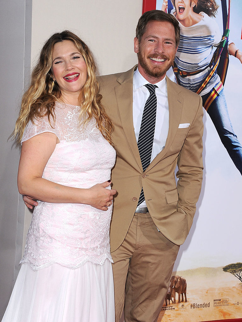 Drew in a lace dress and Will in a suit, smiling at a movie premiere