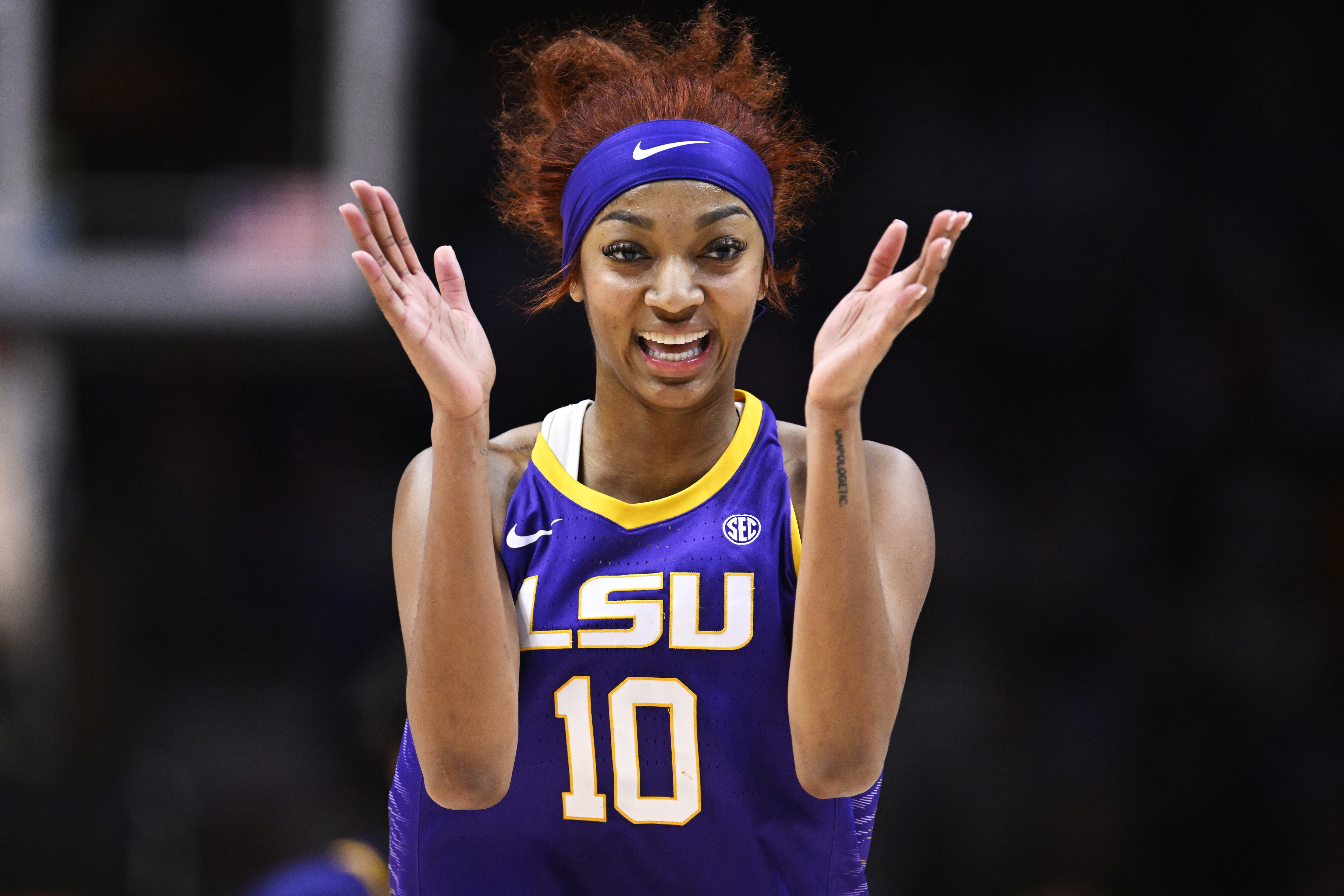 LSU basketball player in uniform gestures with excitement on the court