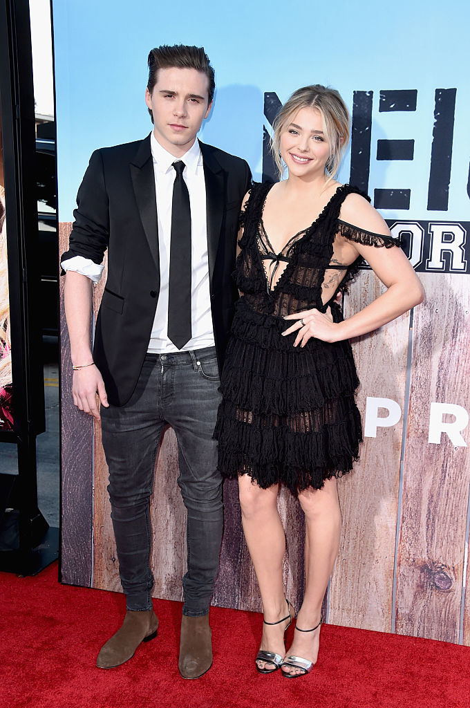 Brooklyn in a casual suit and Chloë in a fringed black dress on the red carpet