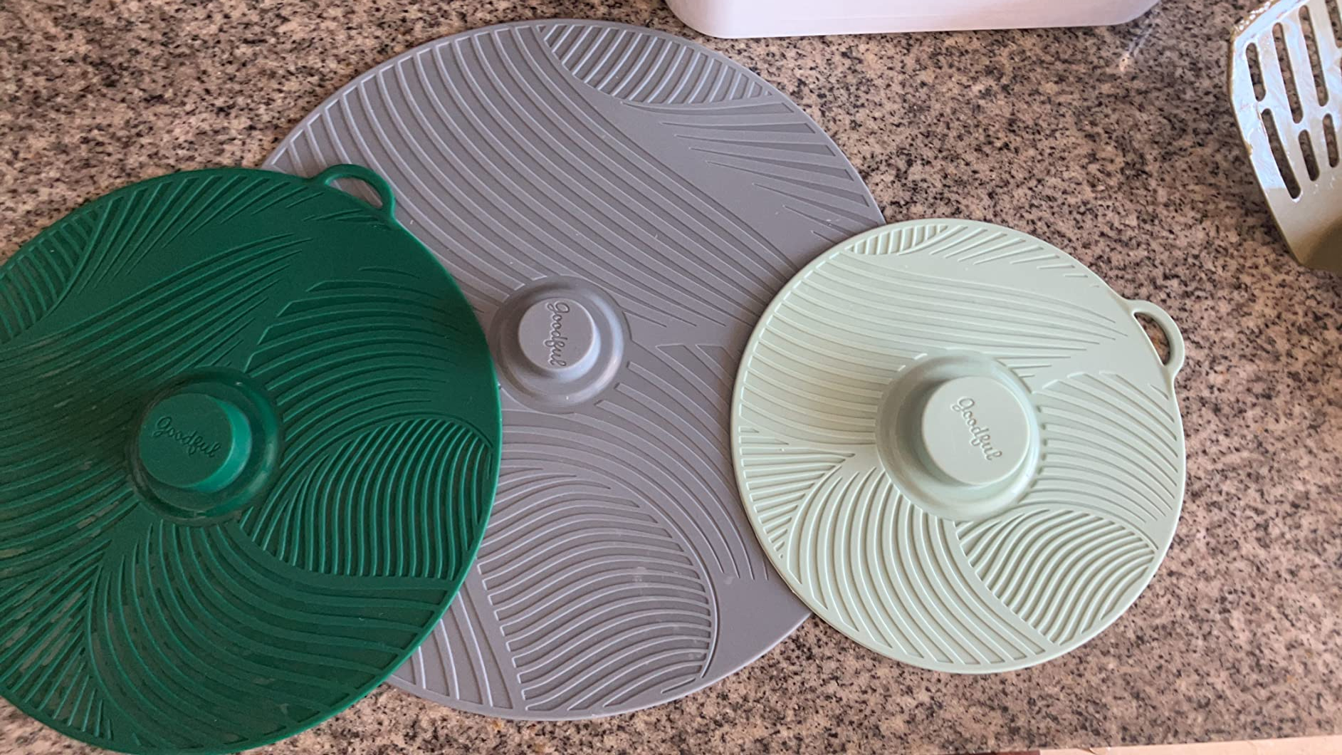 the three silicone lids in different sizes and patterns on a kitchen counter