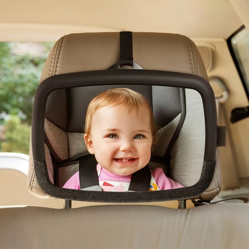 Toddler smiling in a secure car seat with adjustable headrest