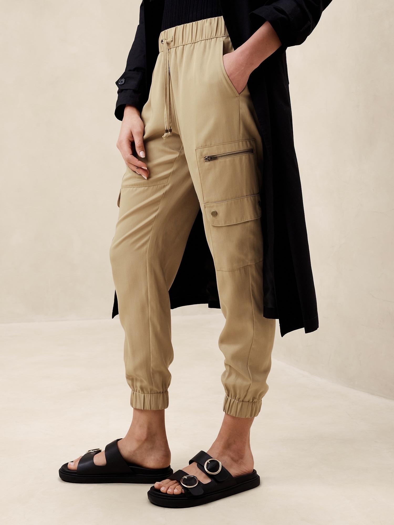 Person wearing khaki cargo pants and black slide sandals