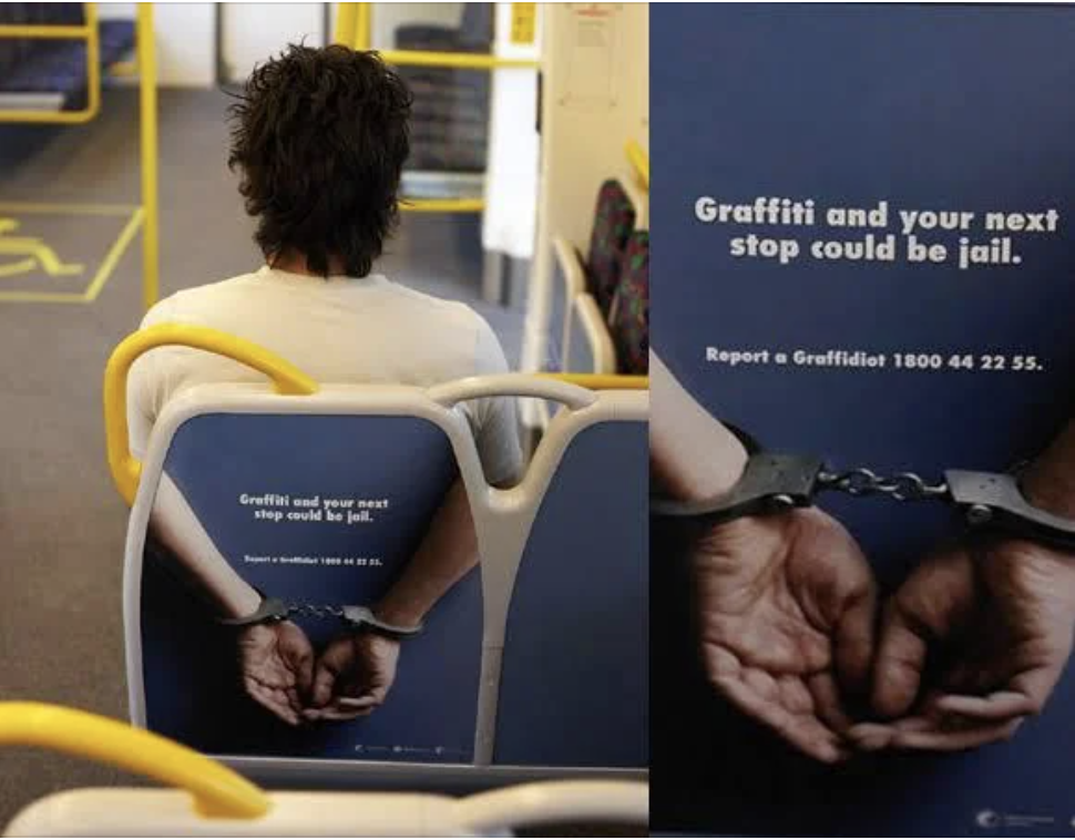 An individual on a bus sits in front of an anti-graffiti ad showing handcuffed hands