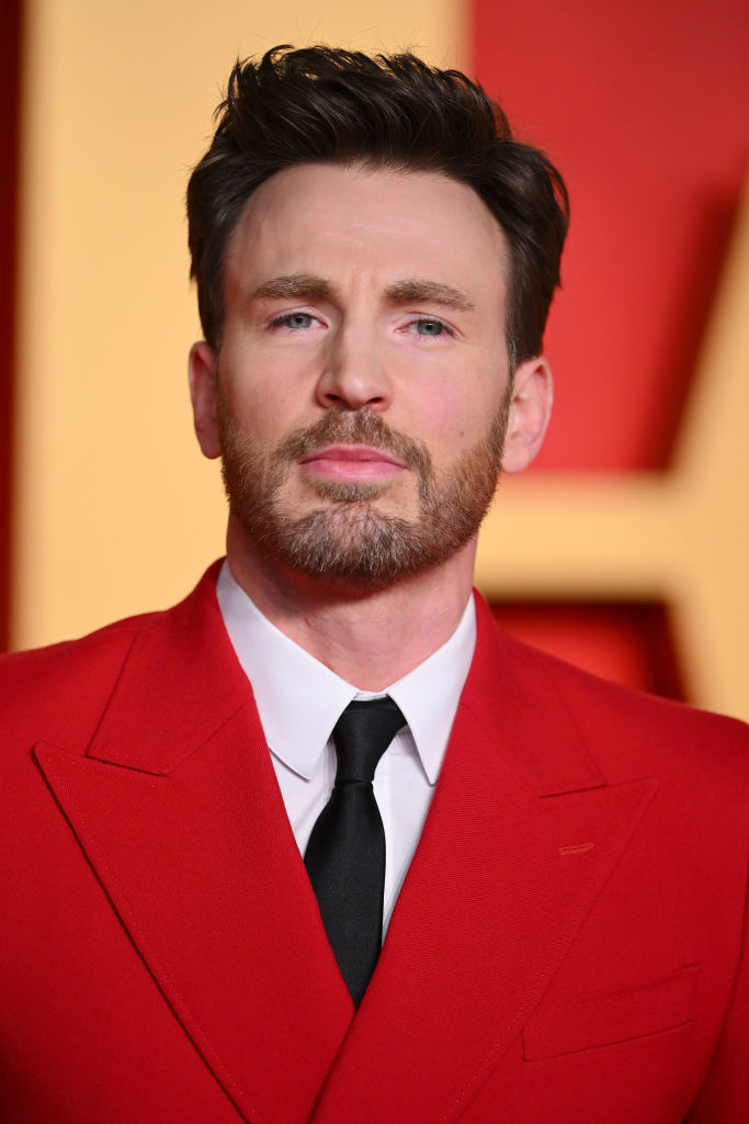 Chris in a red suit jacket posing for the camera