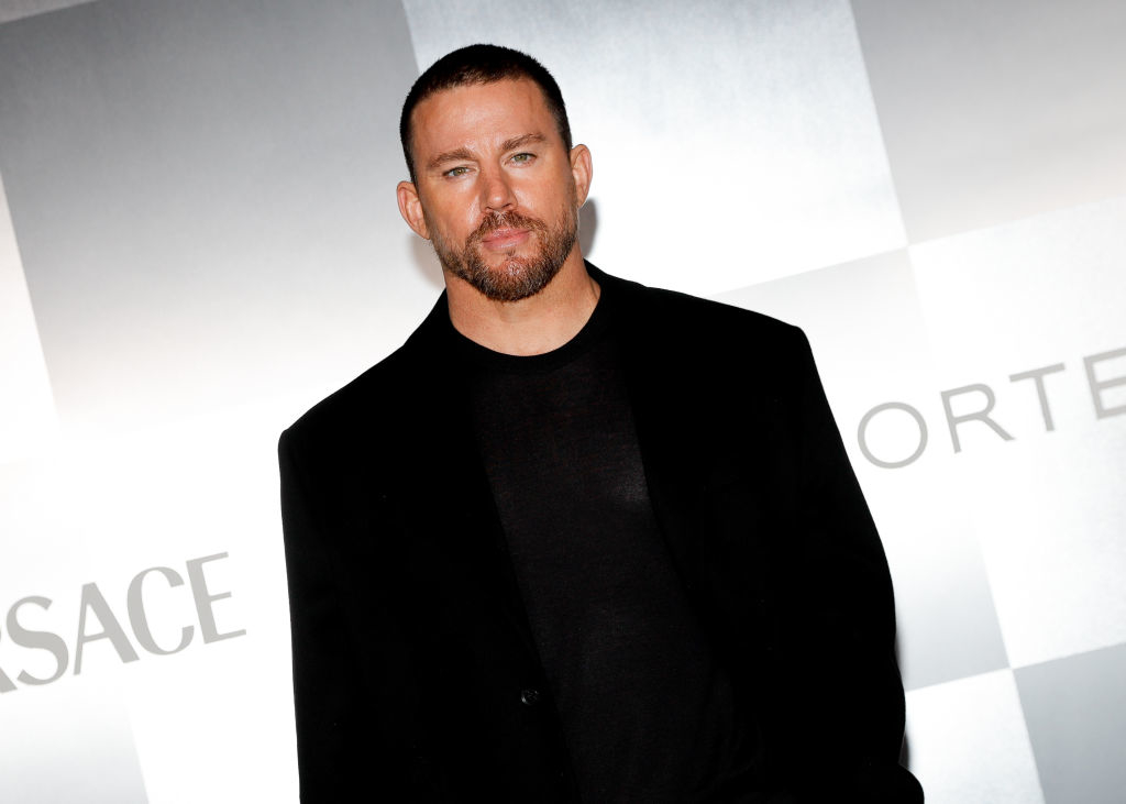Channing in a black outfit posing with hands in pockets at an event