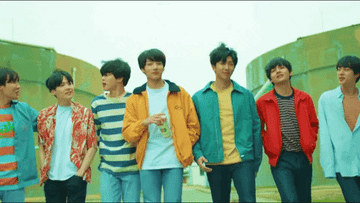 Miembros de BTS caminando juntos al aire libre