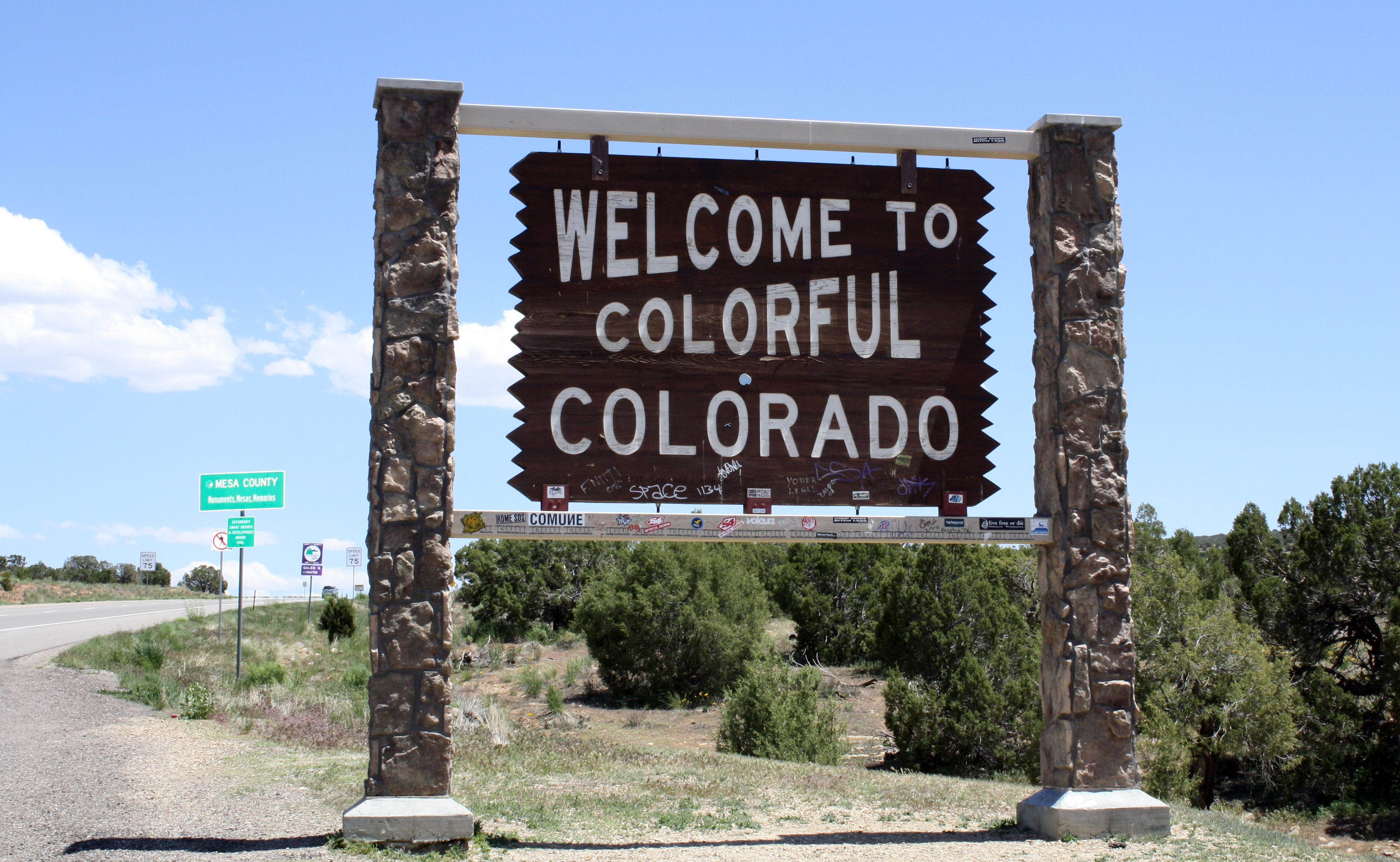 Welcome sign reading &quot;Welcome to Colorful Colorado&quot; at a state border
